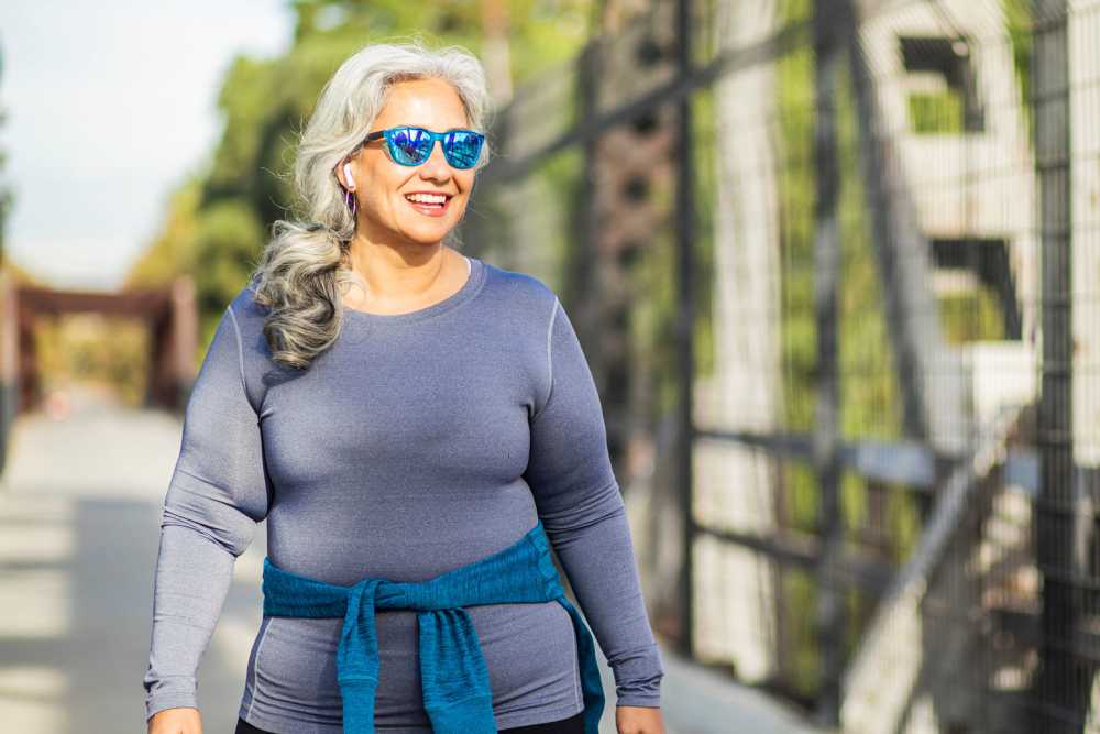 A senior woman exercising outdoors with sunglasses