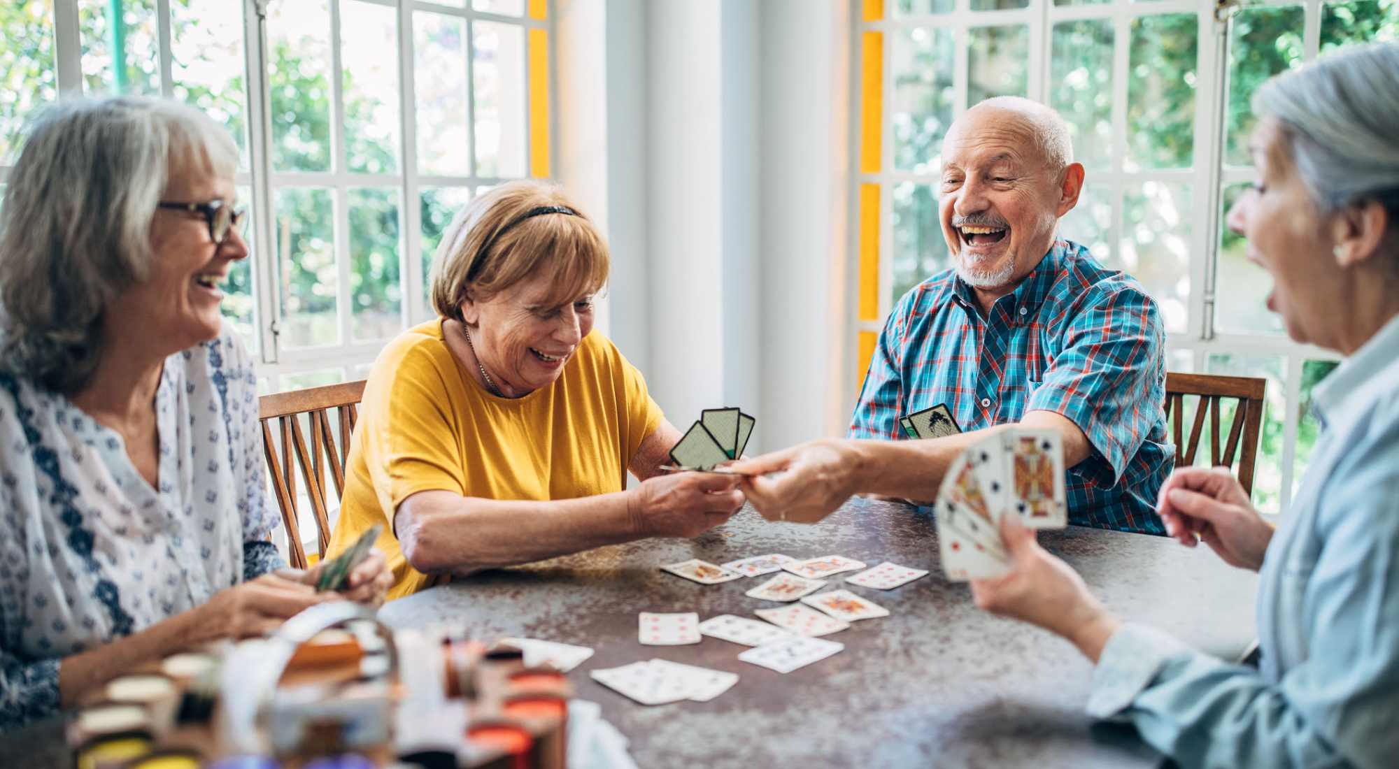Residents enjoying a card game in a bright common space