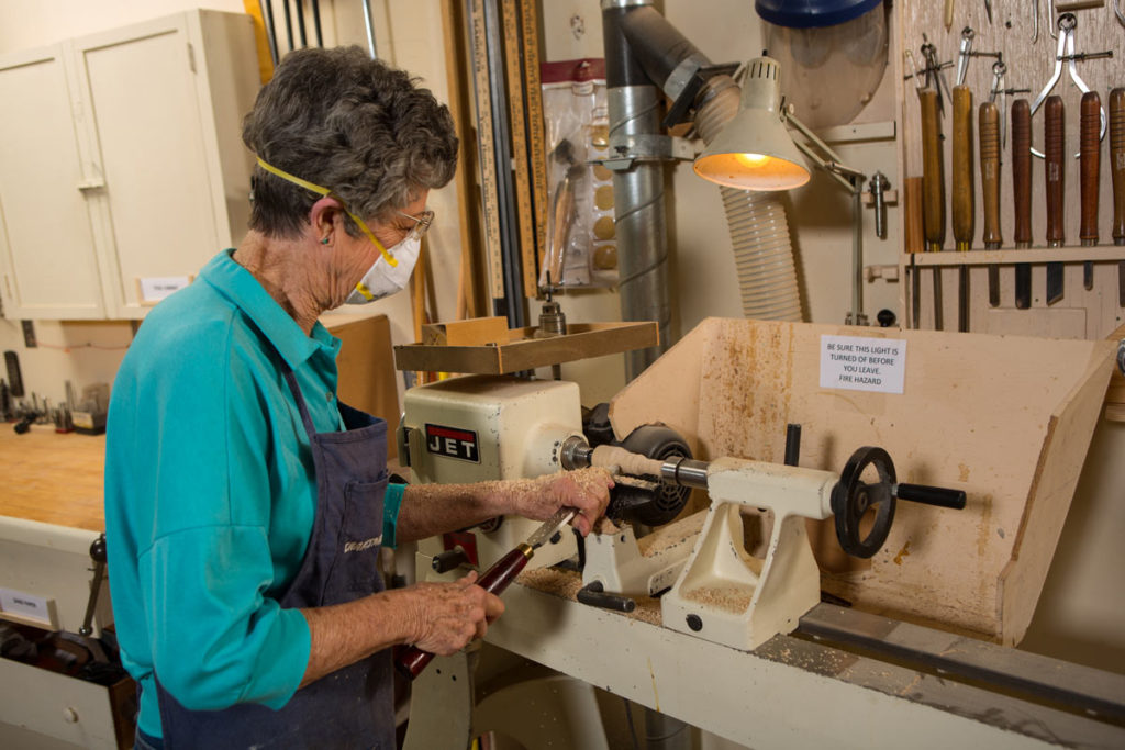 Resident engaged in woodworking activity in a workshop