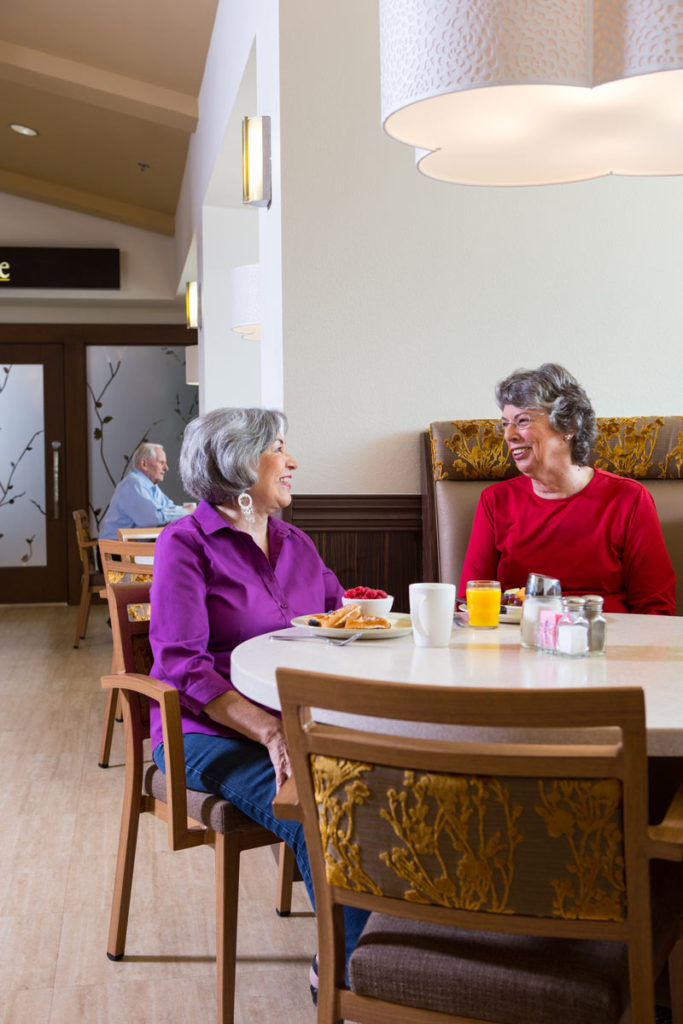 Two residents enjoying breakfast in a dining area