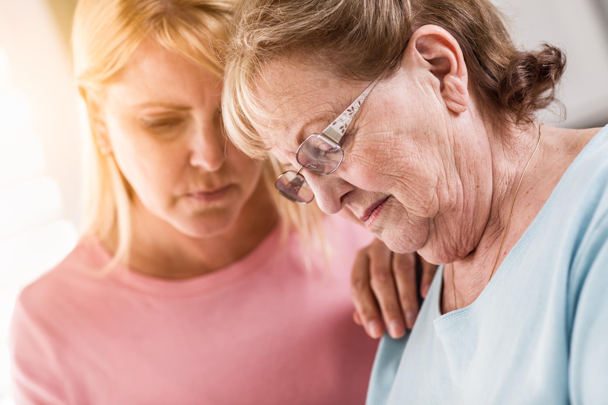Caregiver assisting a senior resident with a thoughtful gesture