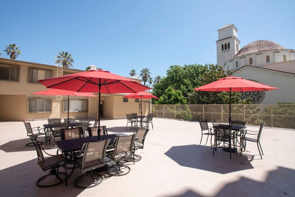 Outdoor seating area with red umbrellas and tables