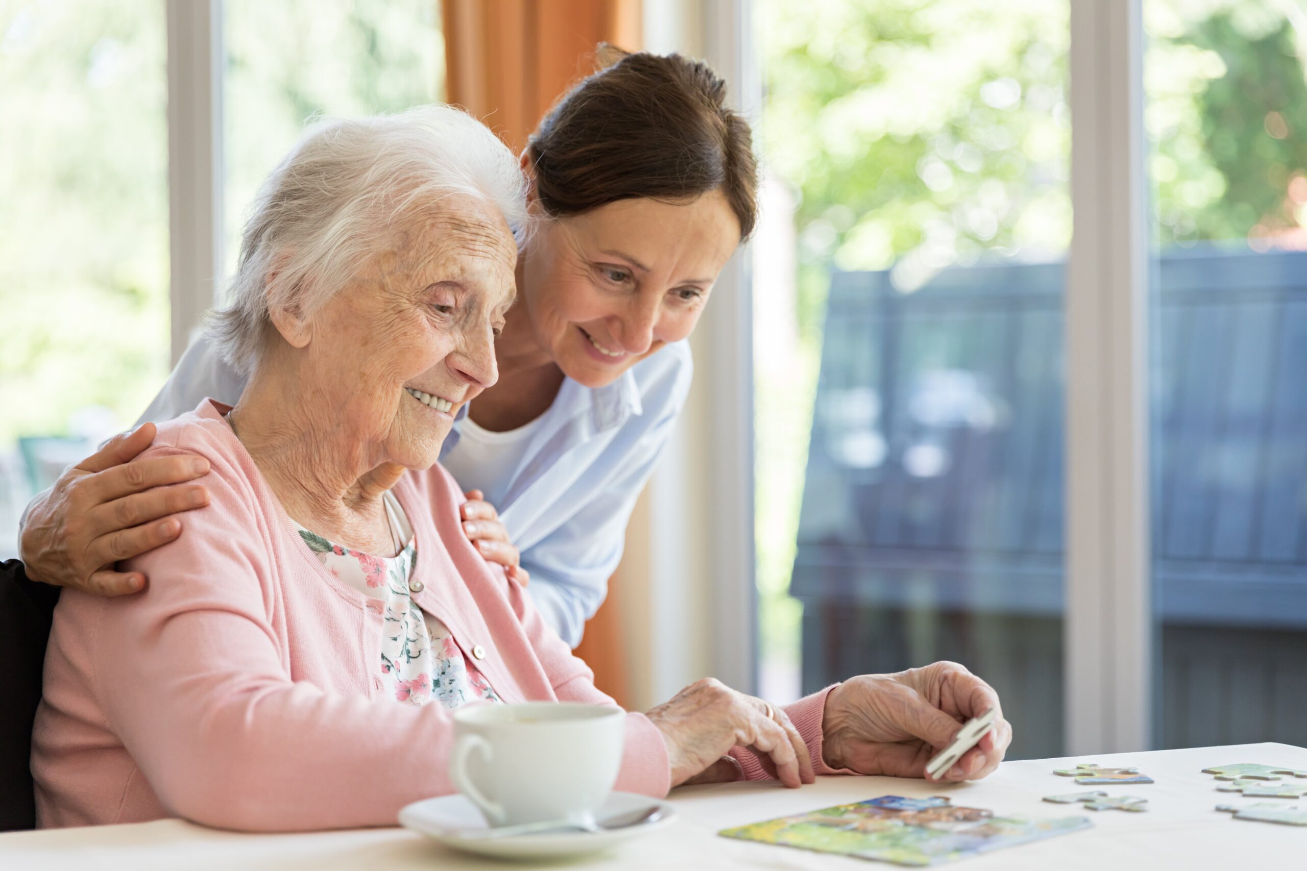 A caregiver and resident enjoying a puzzle together at a table
