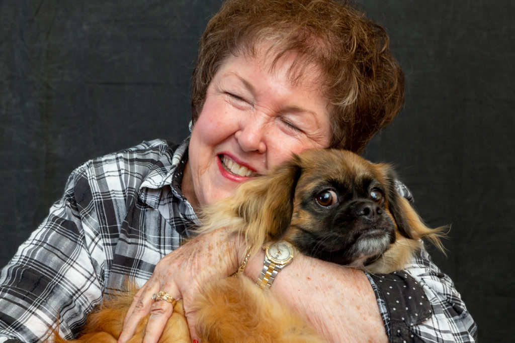 Senior resident smiling with a dog.