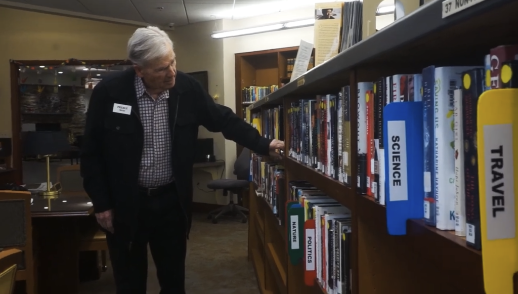 Resident browsing books in a cozy library space