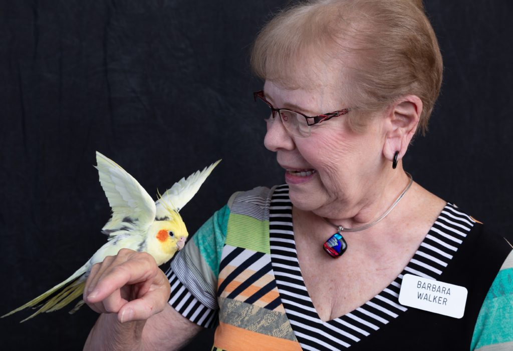 Senior woman interacting with a bird in a friendly setting