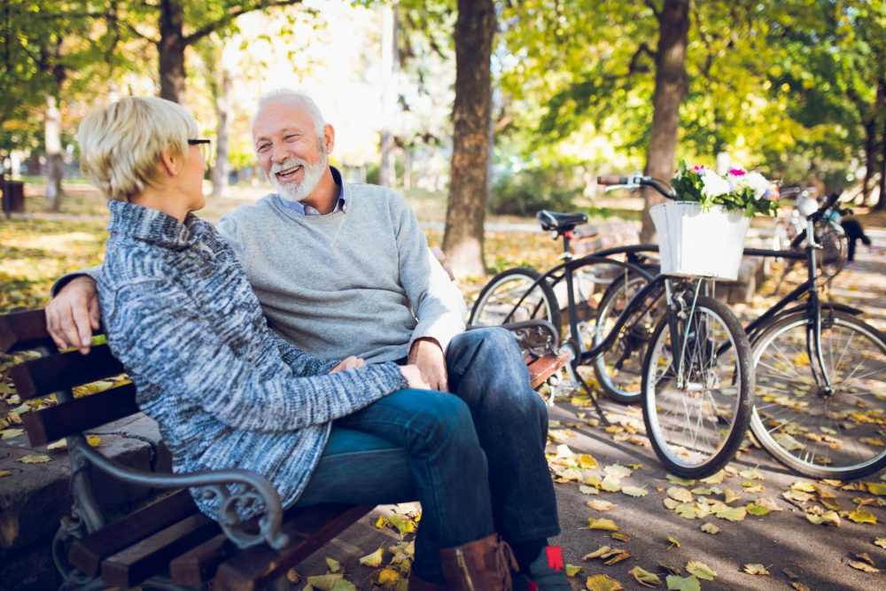 A couple enjoying a conversation on a park bench in autumn