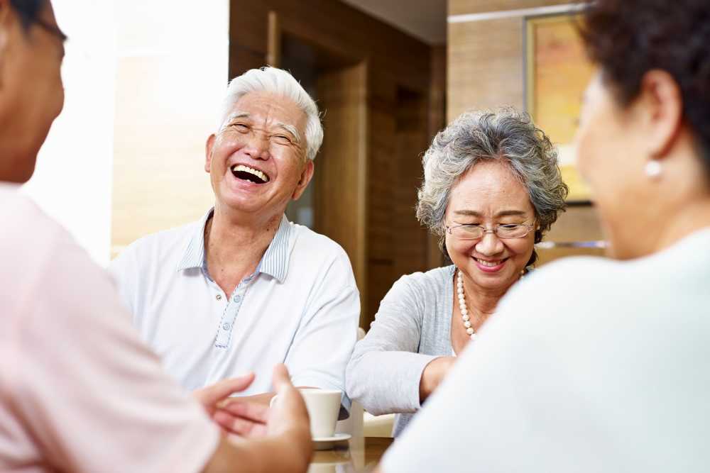 Residents laughing and enjoying conversation at a table