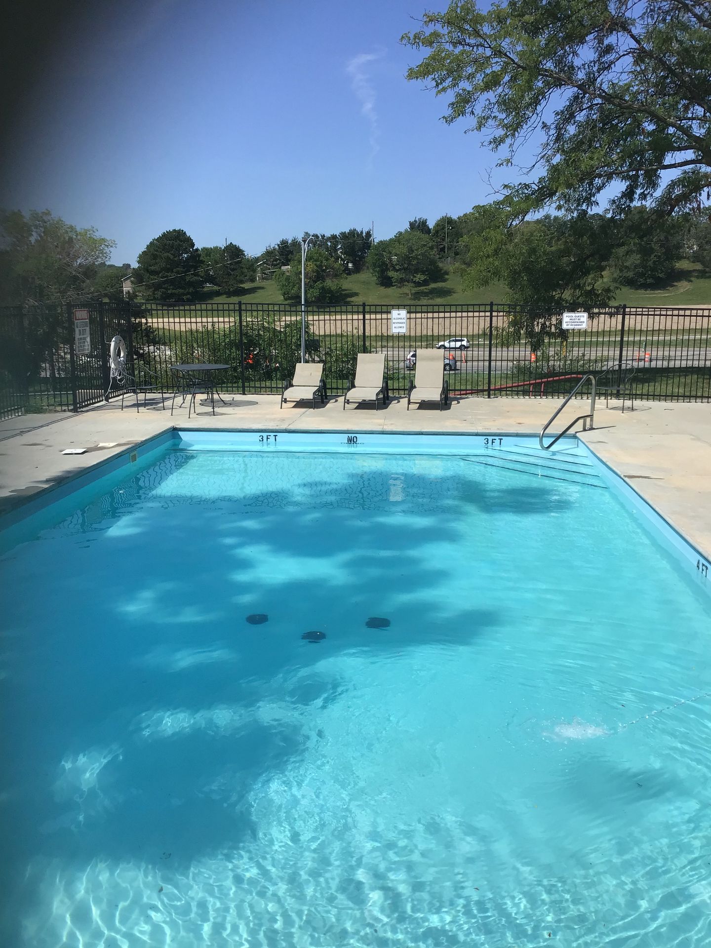 A serene outdoor swimming pool with lounge chairs