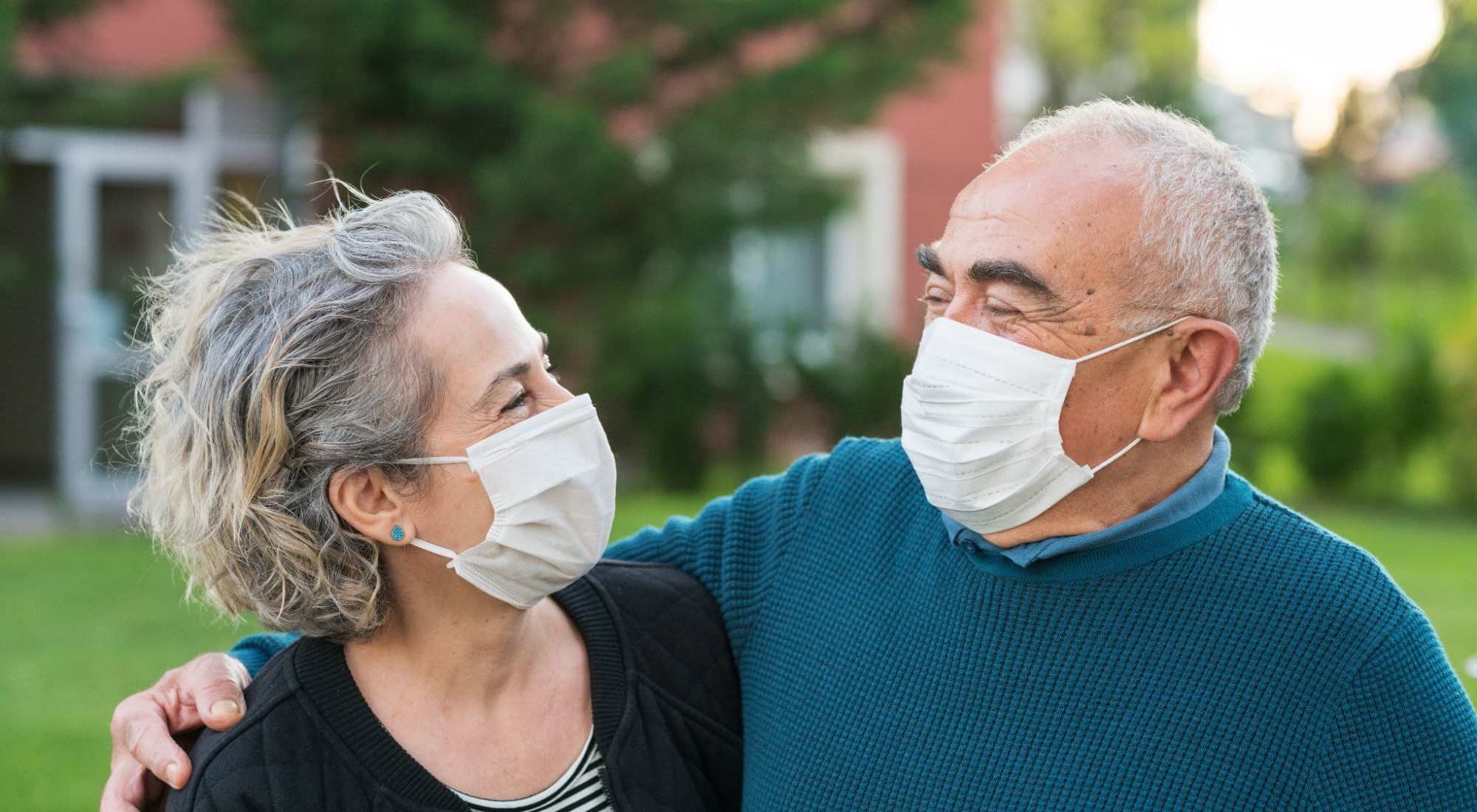 Residents smiling outdoors wearing masks
