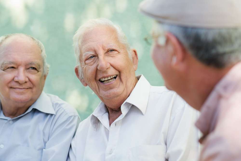 Three senior men enjoying a light-hearted conversation