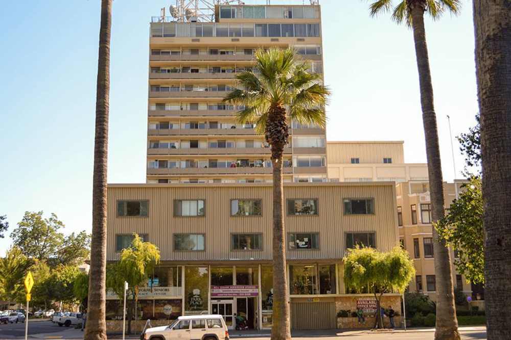 Exterior view of Park Place Apartments building with palm trees