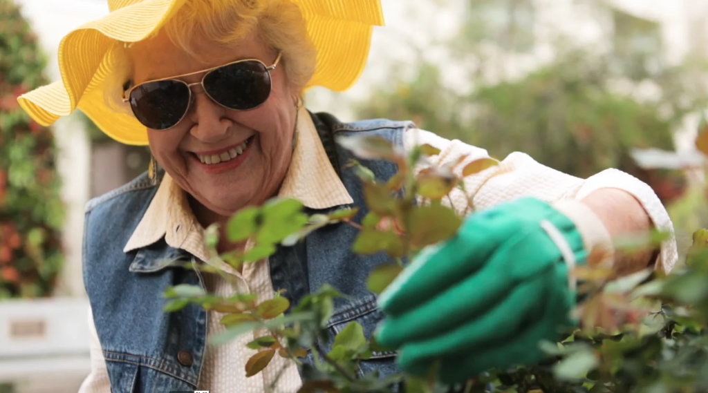 Senior resident gardening outdoors with a bright smile