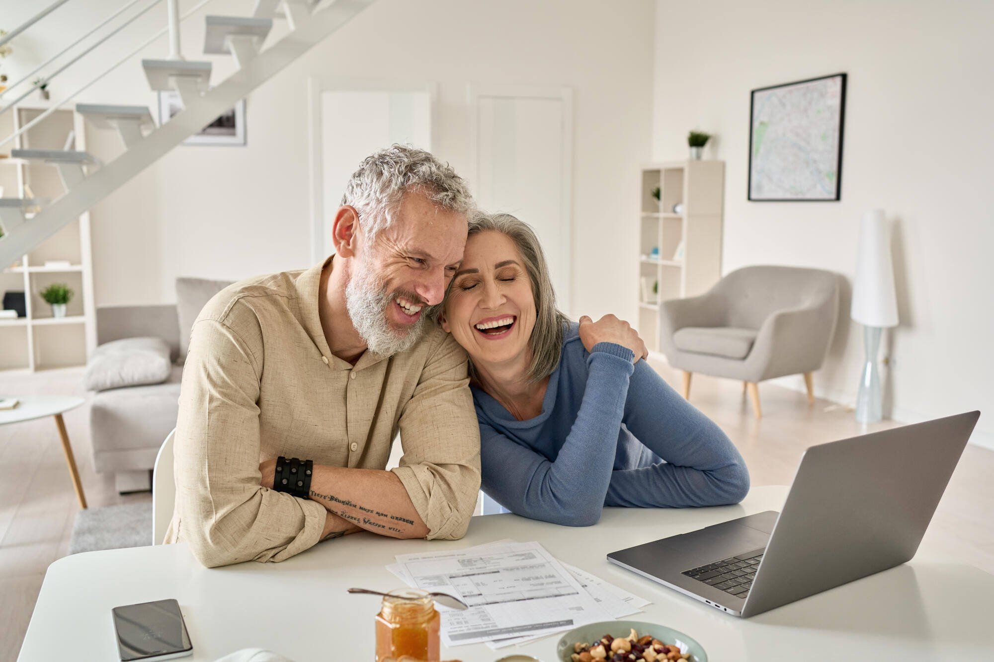 A happy couple enjoying time together at a table with a laptop