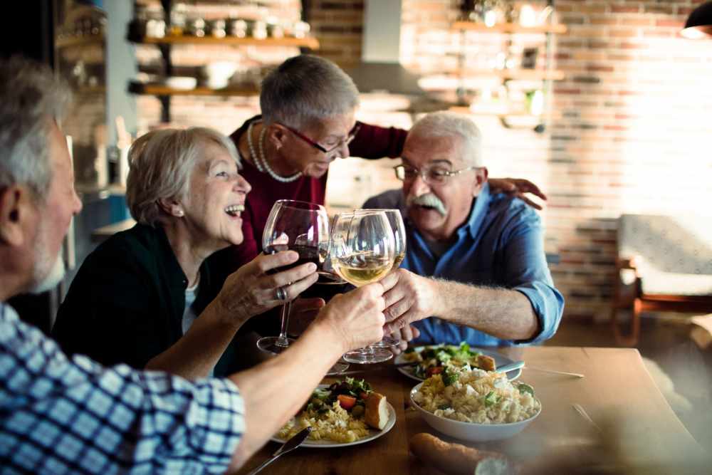 Residents enjoying a meal and toasting in a dining area
