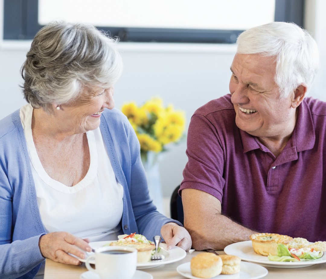Seniors enjoying a meal together with laughter