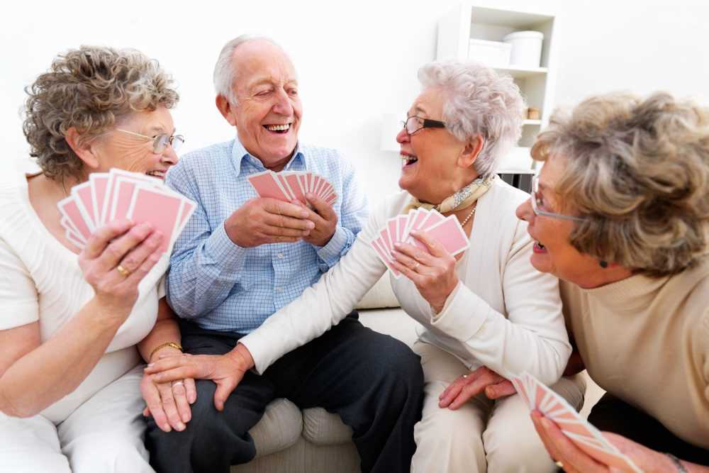 Residents playing cards in a bright common area