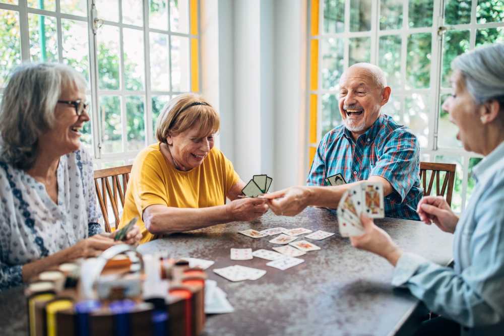 Residents enjoying a card game in a sunlit room