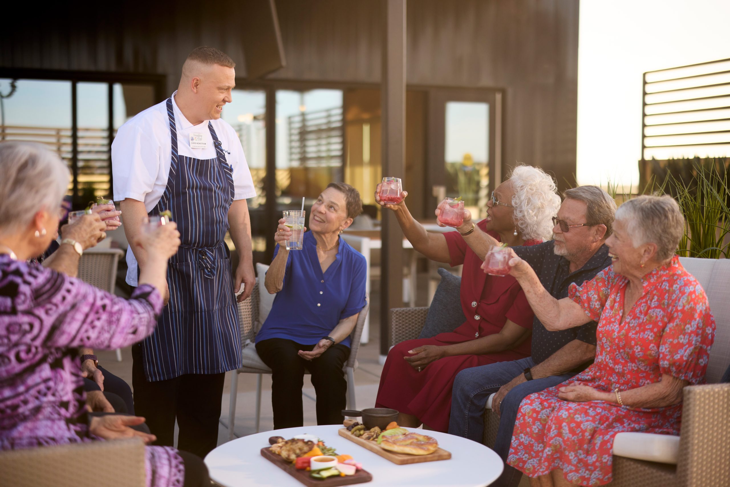 Residents enjoying a social gathering outdoors with drinks