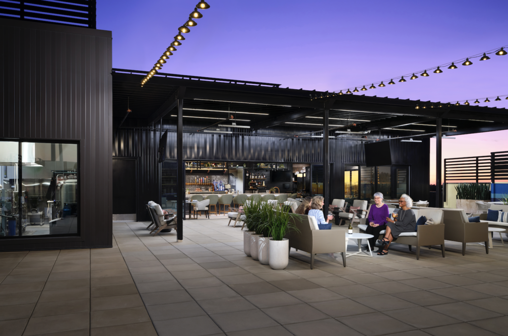 Residents enjoying an outdoor lounge area with comfortable seating