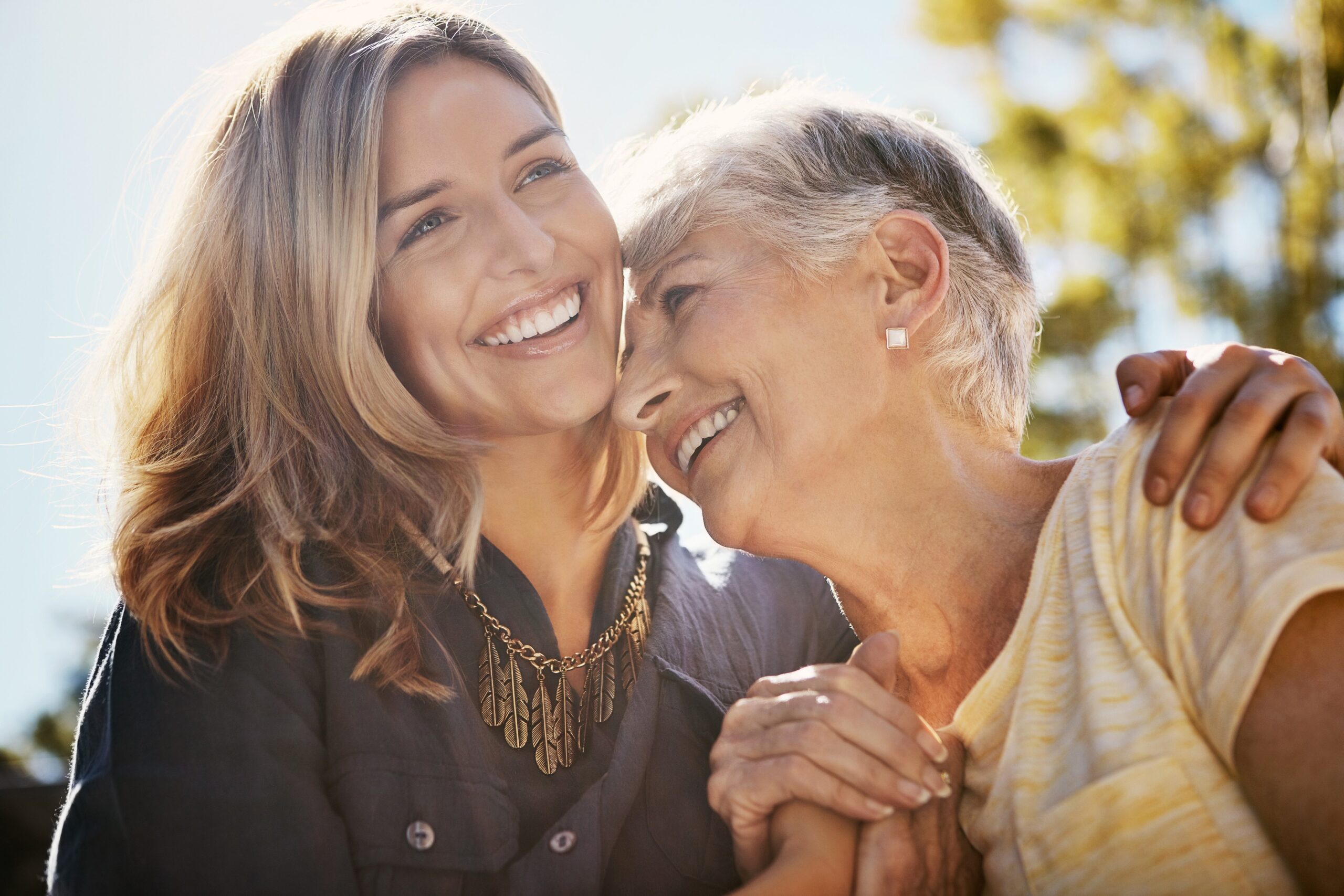 A caregiver laughing with a resident outdoors