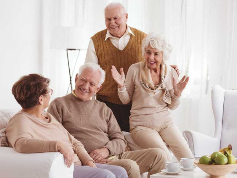 Seniors enjoying conversation in a bright common area