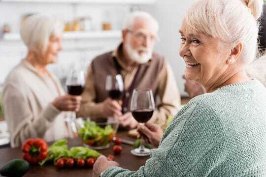 Residents enjoying a meal with drinks at a table