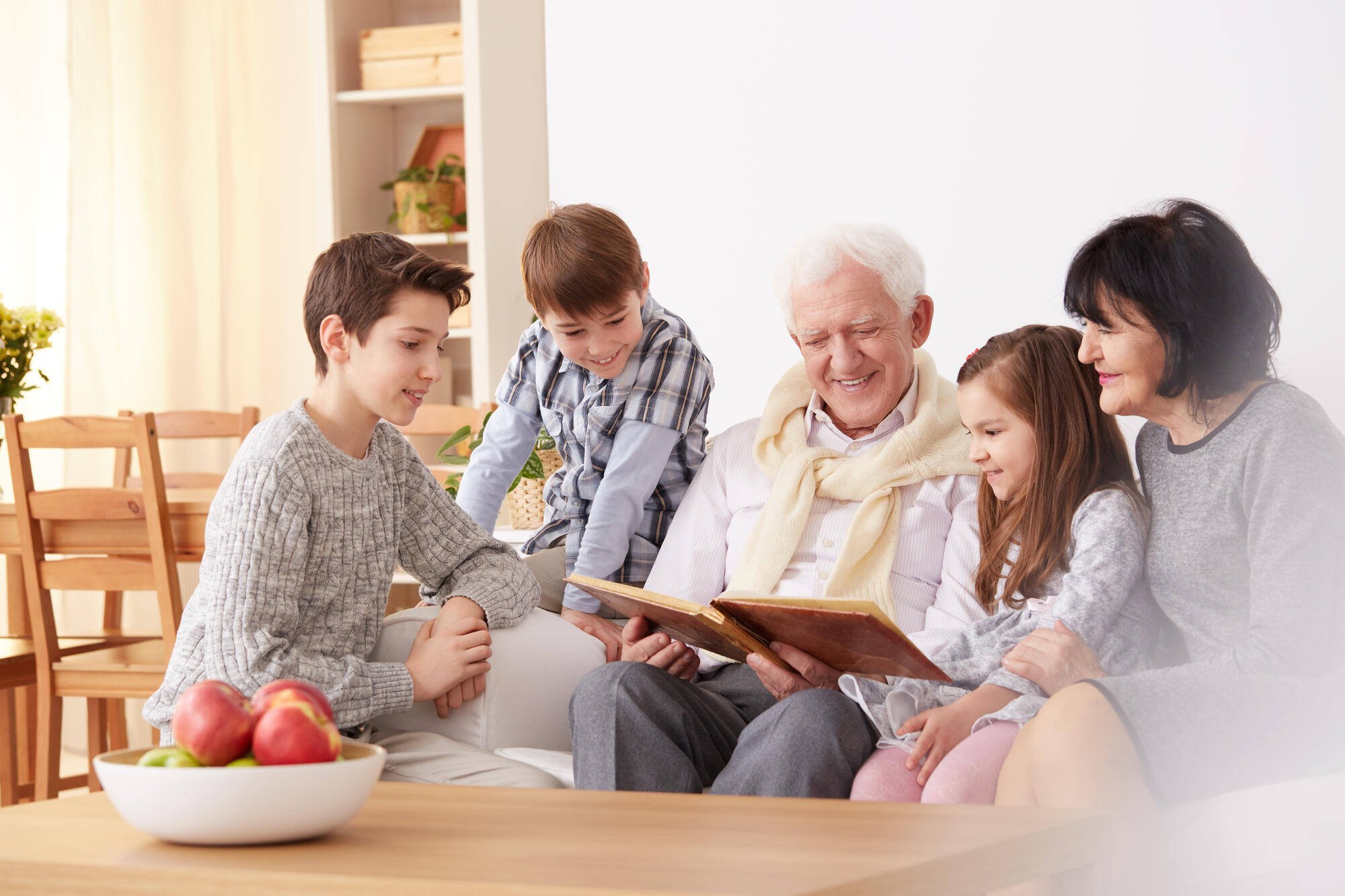 Seniors reading with children in a cozy living room