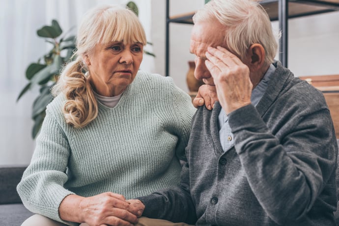 A senior woman comforting a distressed senior man