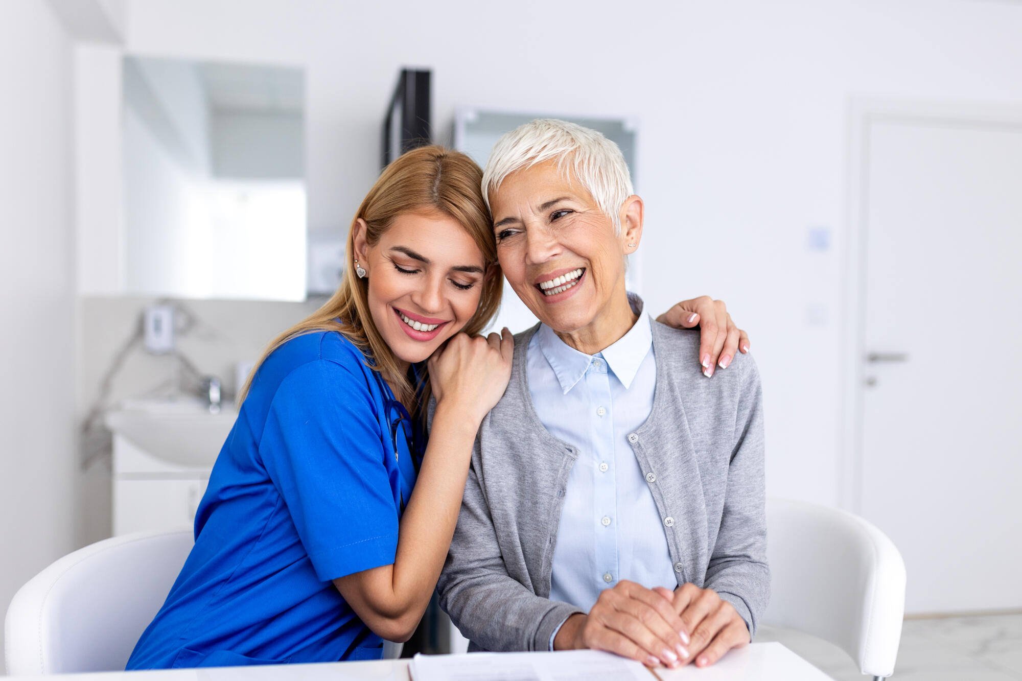 Caregiver and resident smiling together in a cozy space