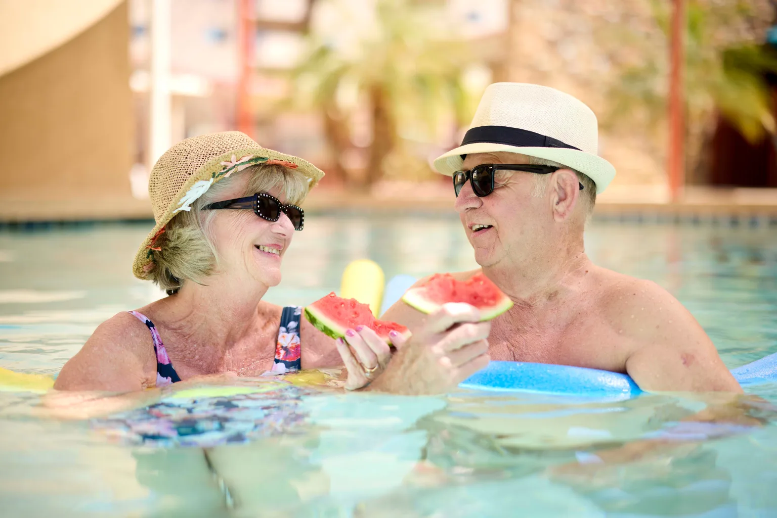 Seniors enjoying watermelon in a swimming pool