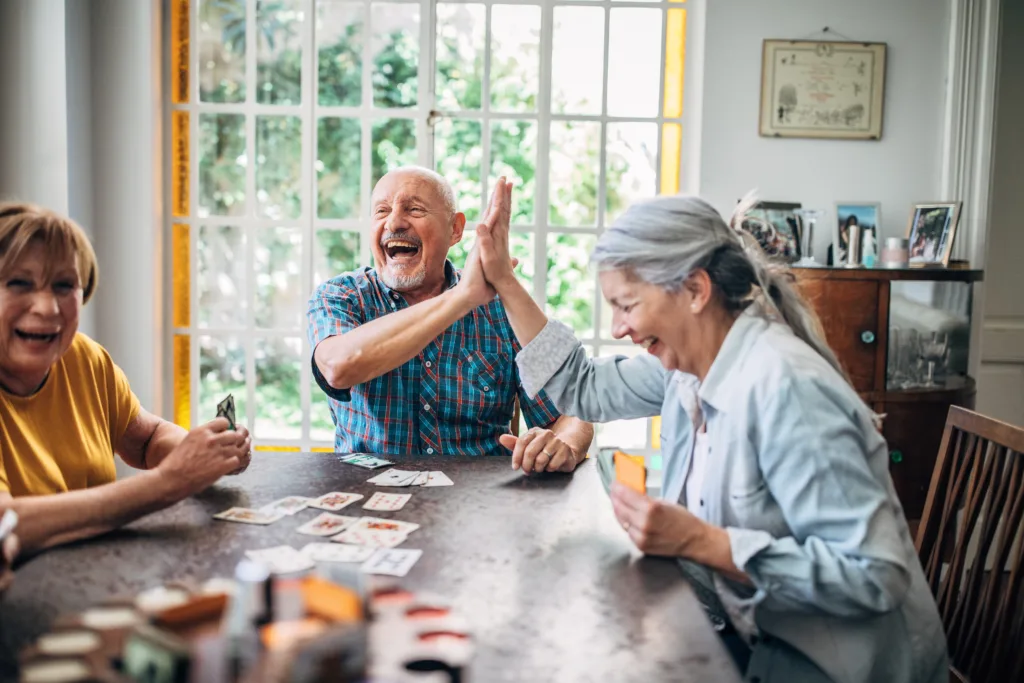 Residents enjoying a card game in a bright common area