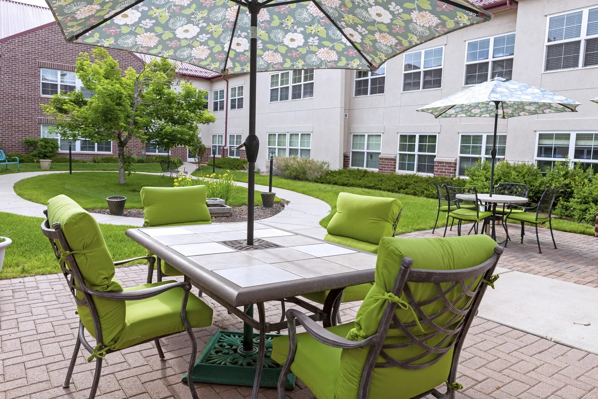 Outdoor seating area with green chairs and umbrellas
