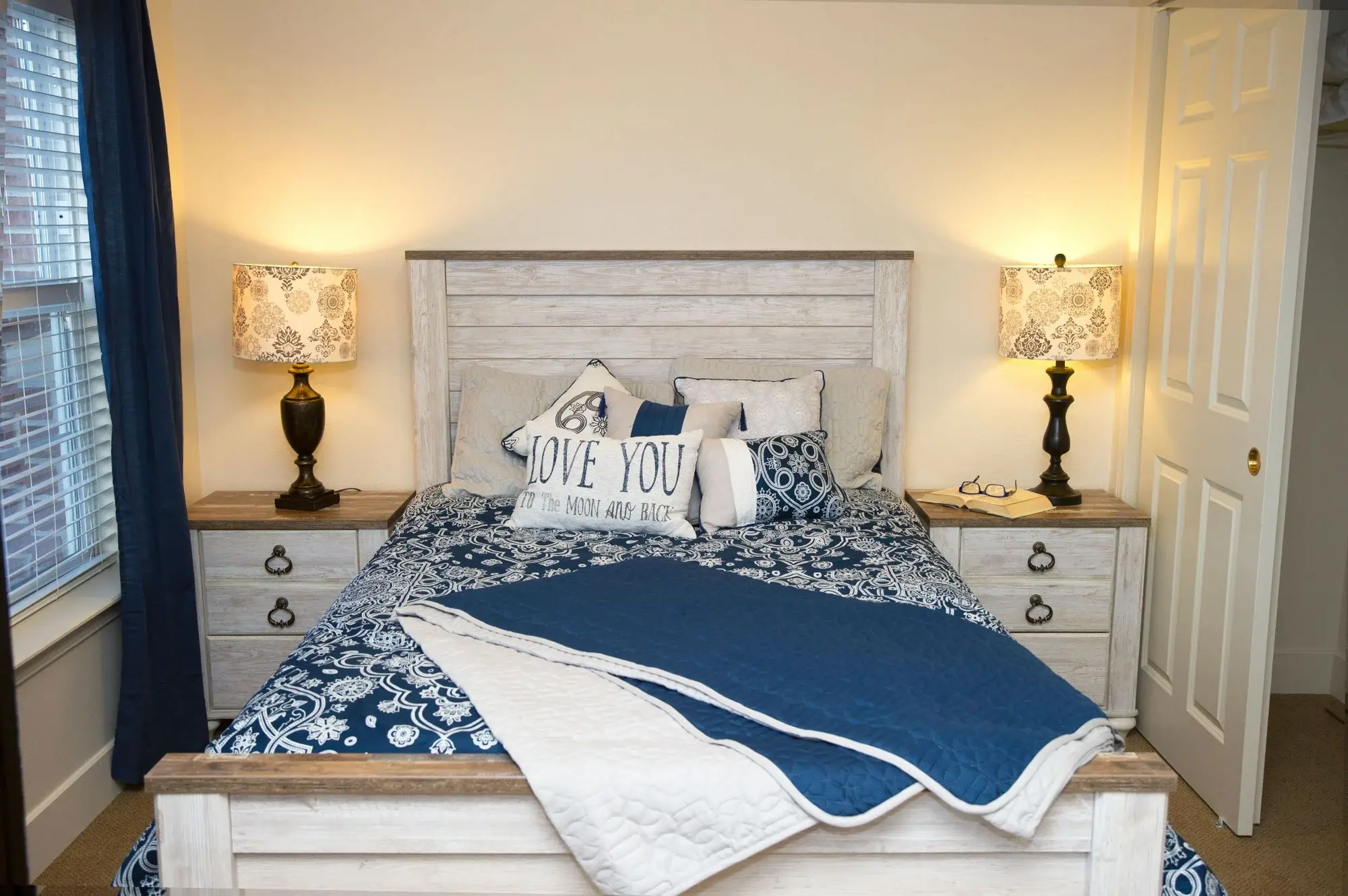 A well-decorated bedroom with soft lighting and blue accents