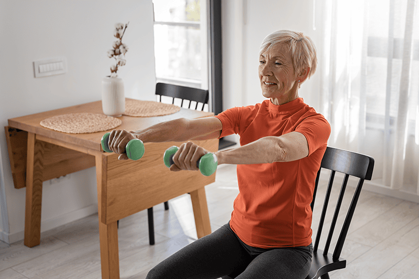 Senior woman exercising with dumbbells in a bright space