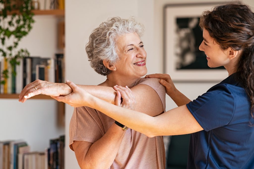 Caregiver assisting resident with mobility exercise