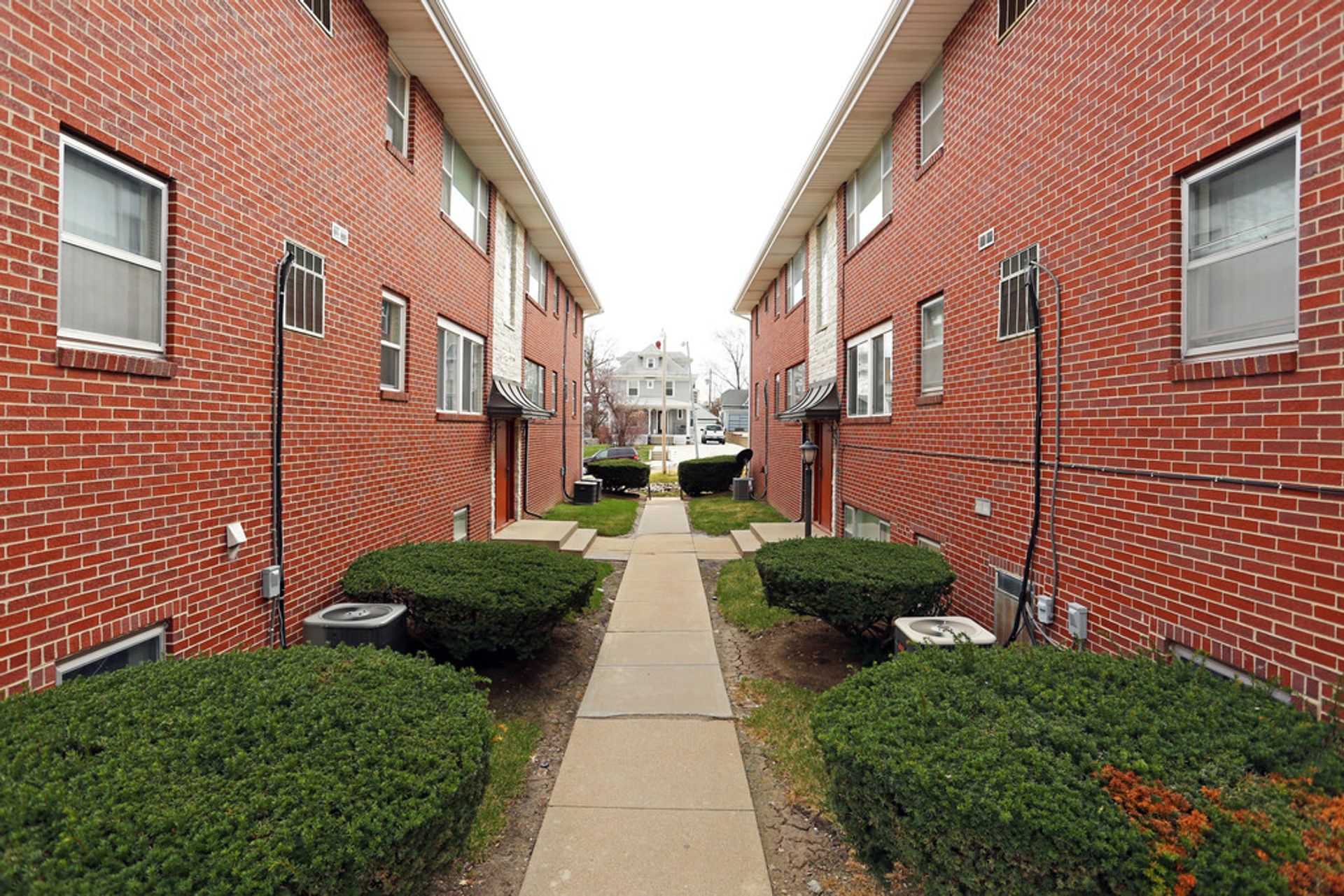 Pathway between residential buildings with landscaping