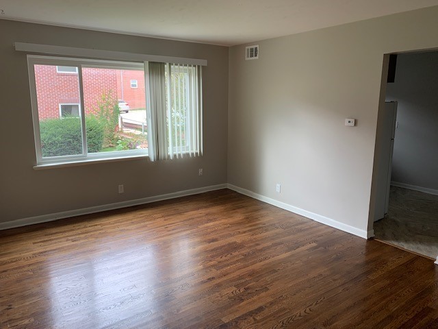 Bright interior room with hardwood floors and large window