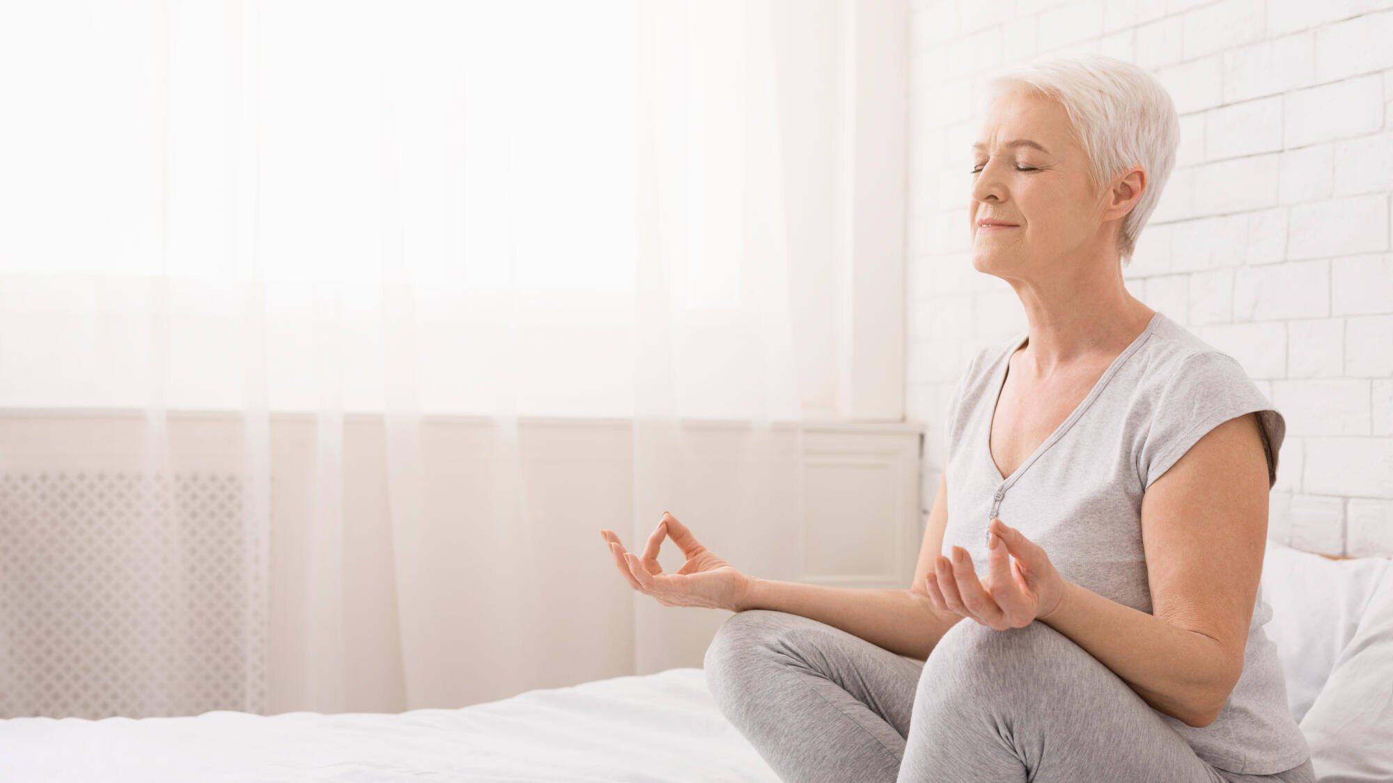 Senior woman meditating in a serene interior space