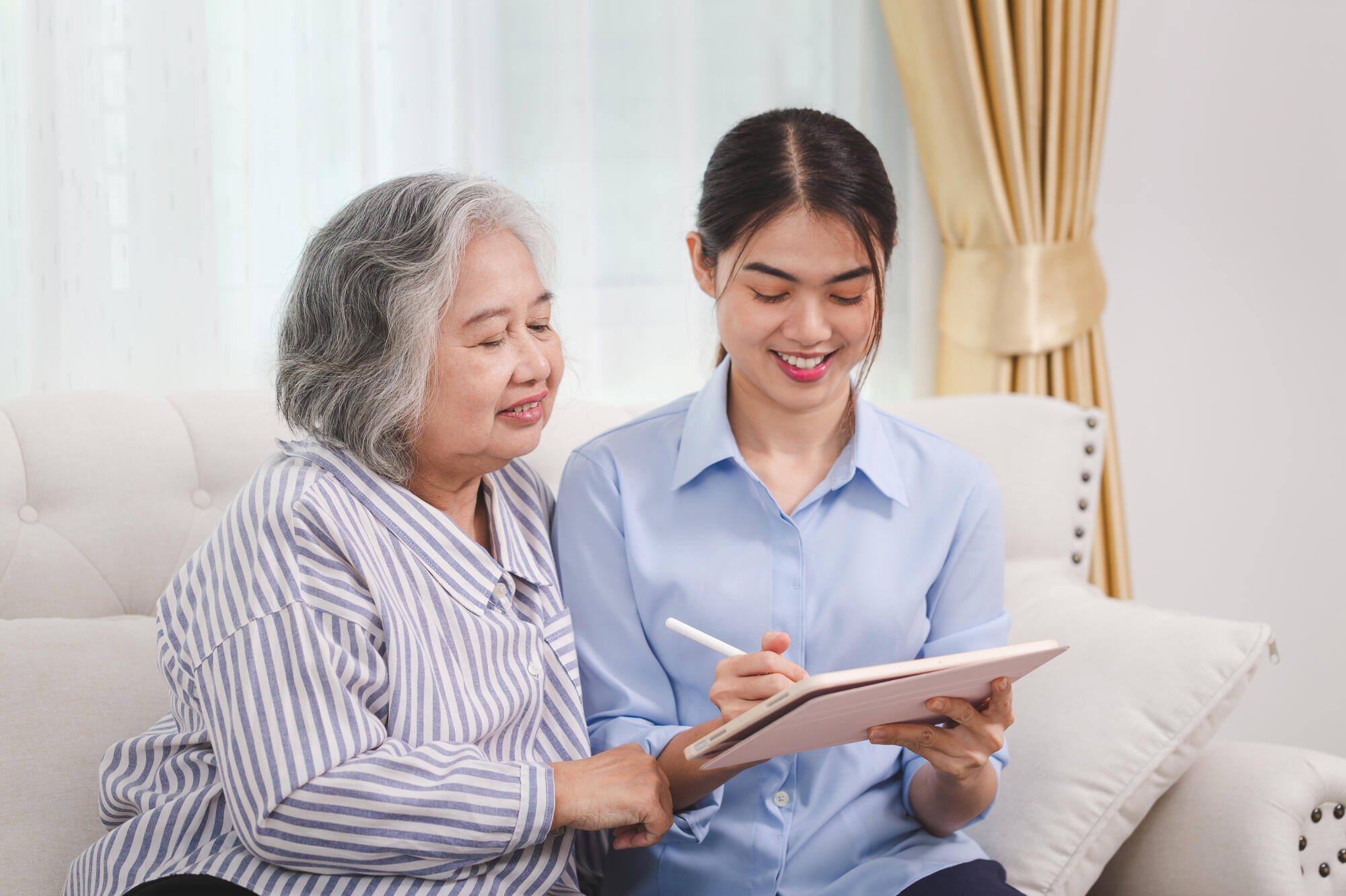 A caregiver assisting a senior resident with writing