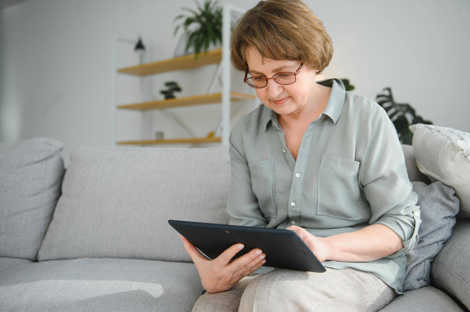 Resident using a tablet in a cozy living room setting