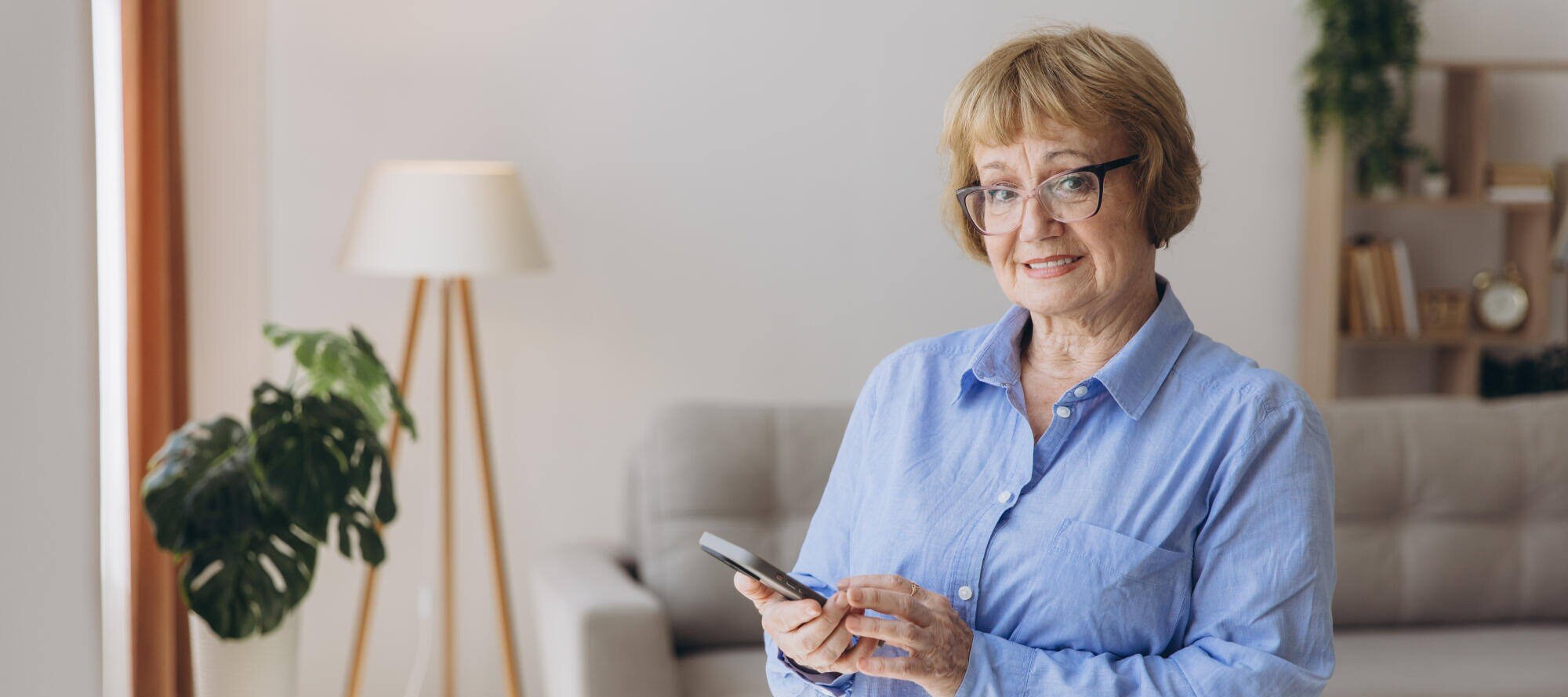 Senior woman smiling while using a smartphone