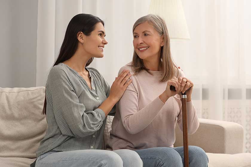 Two women smiling and chatting in a cozy common area