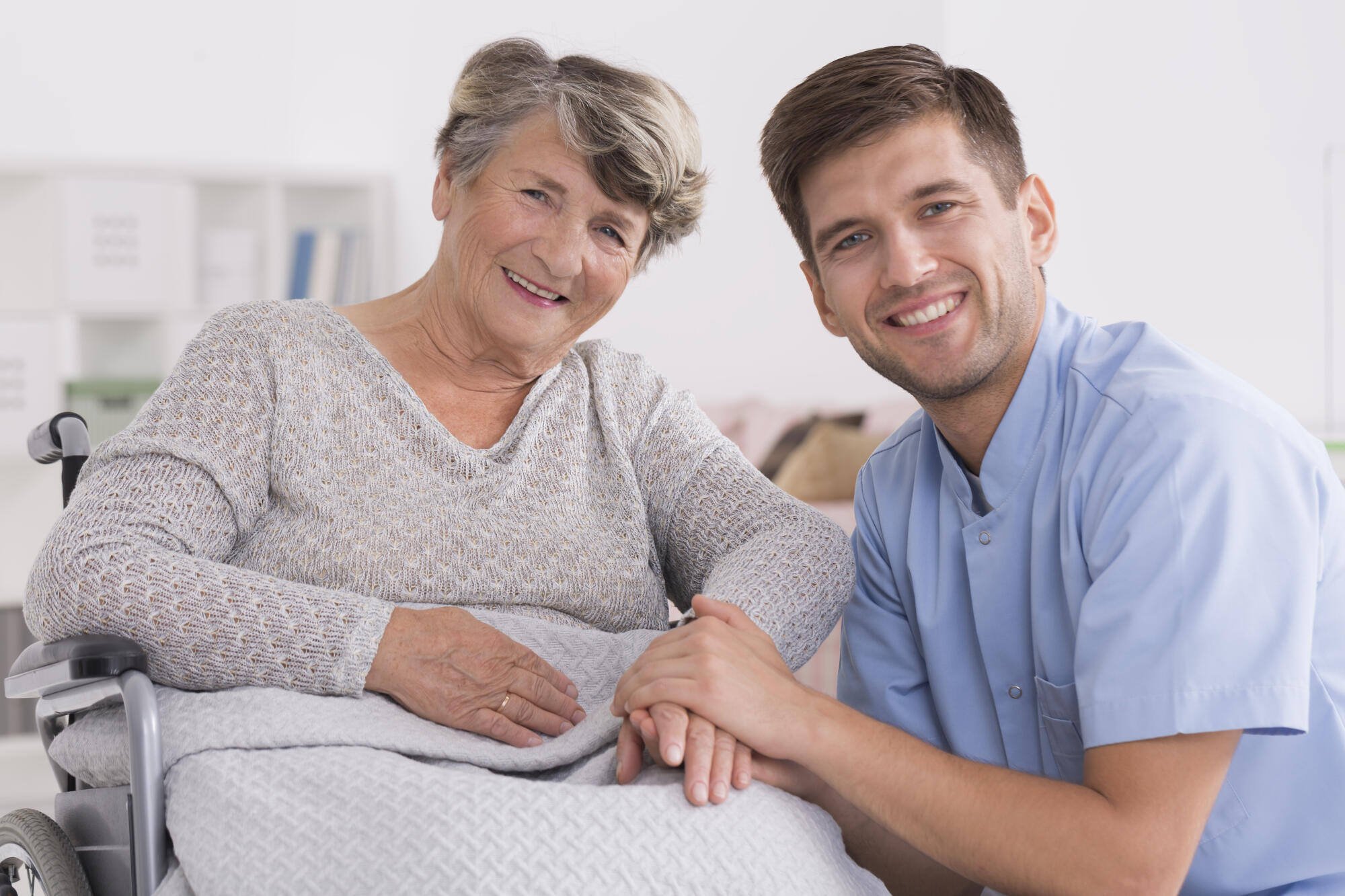 A caregiver smiling with a senior resident in a bright room