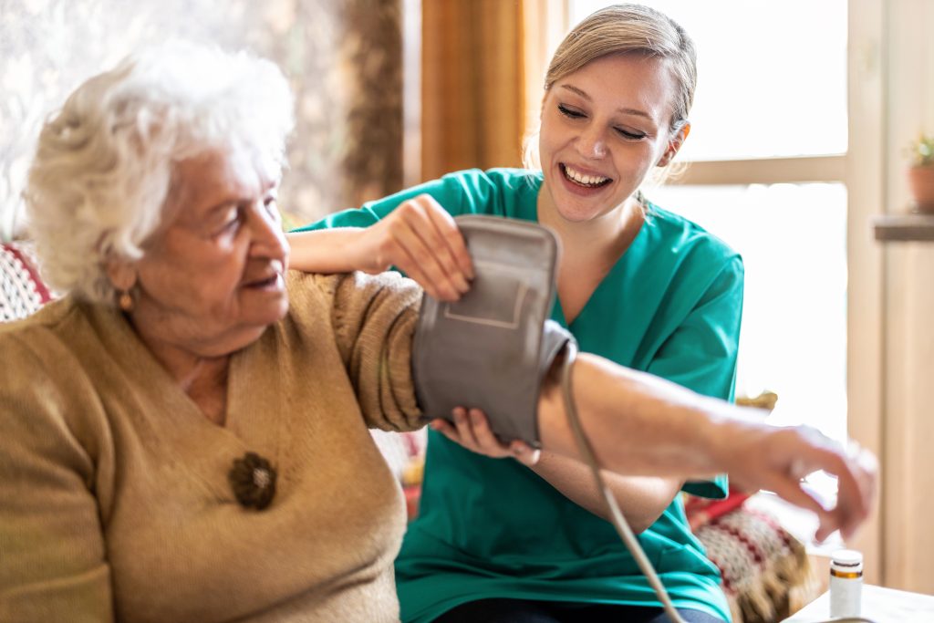 Nurse taking blood pressure of a senior resident