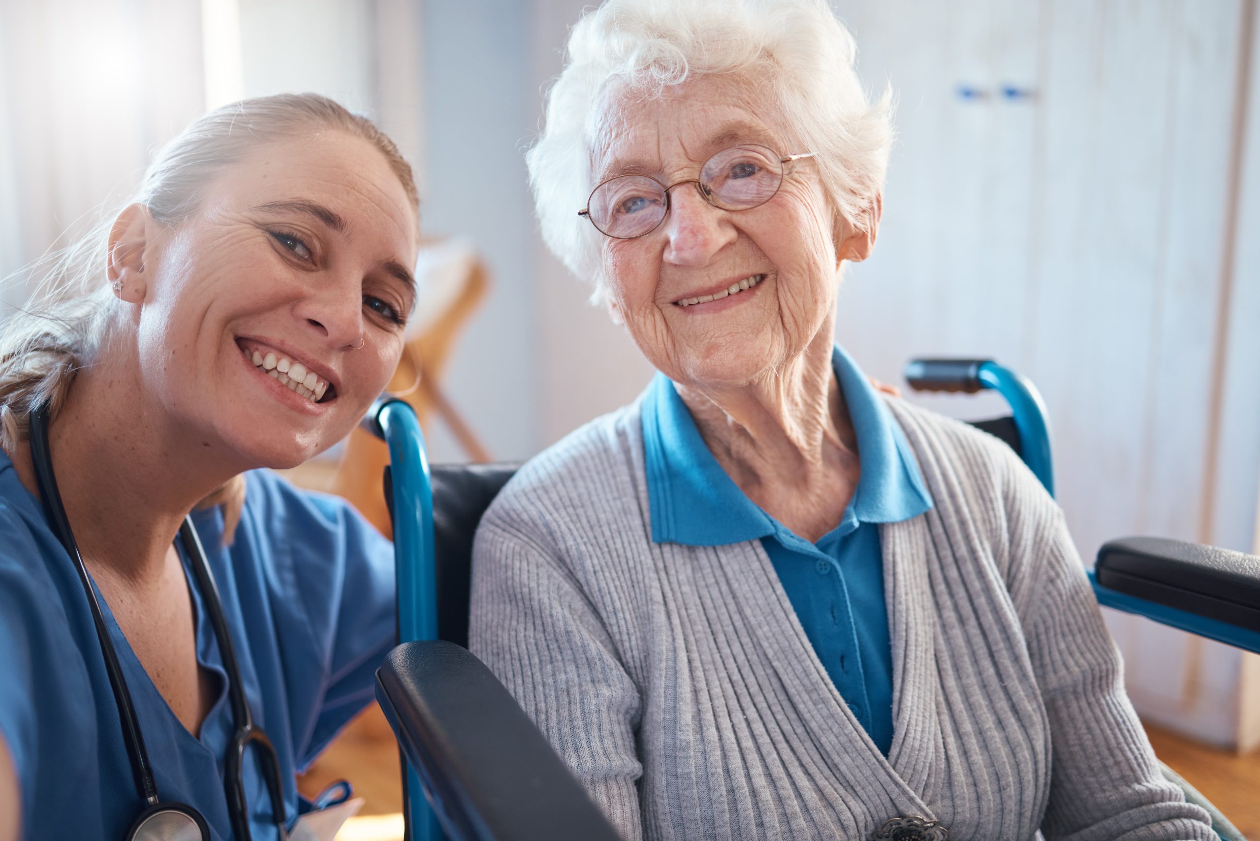 A caregiver smiling with a resident in a bright room