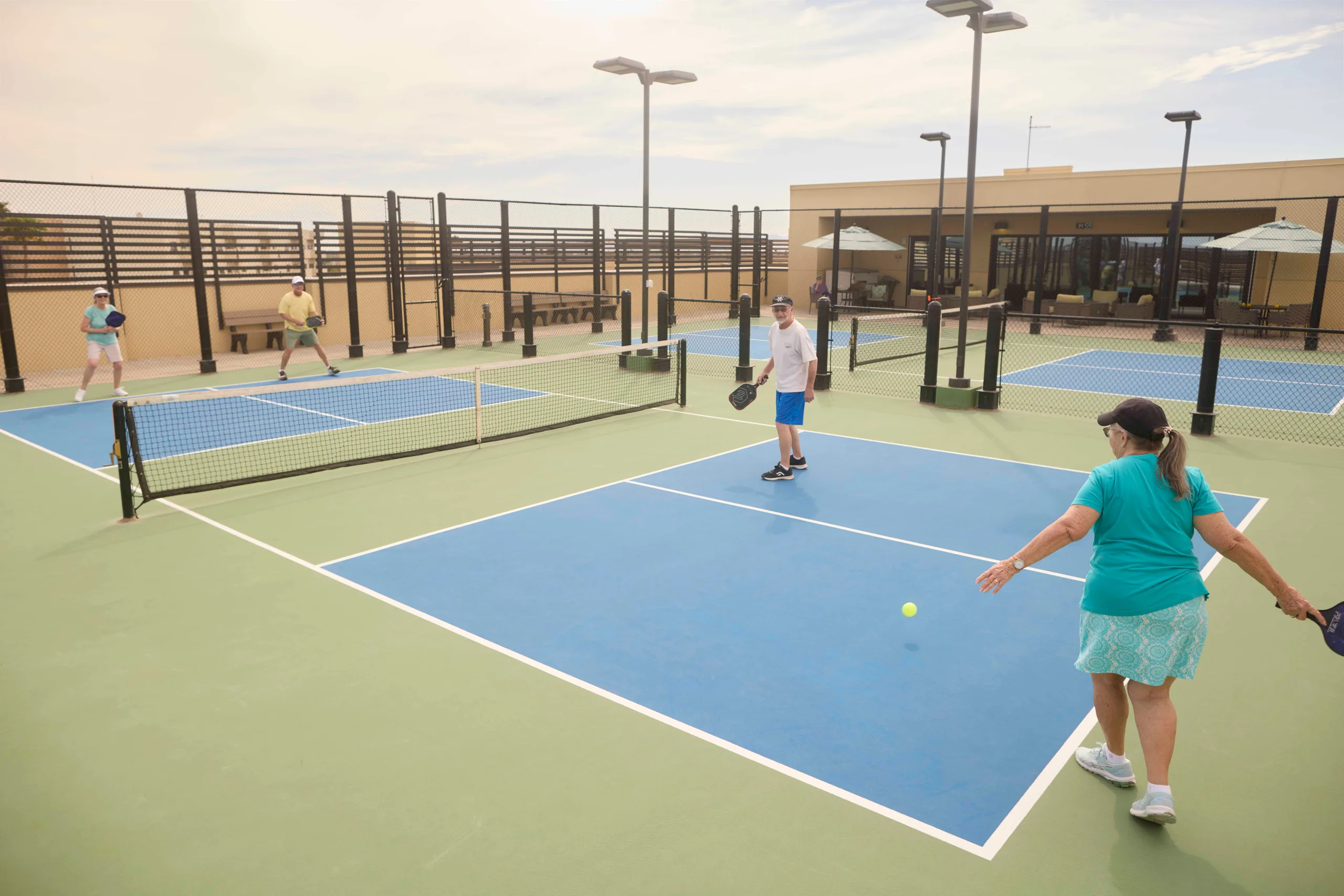 Residents enjoying a game of pickleball on a sunny day
