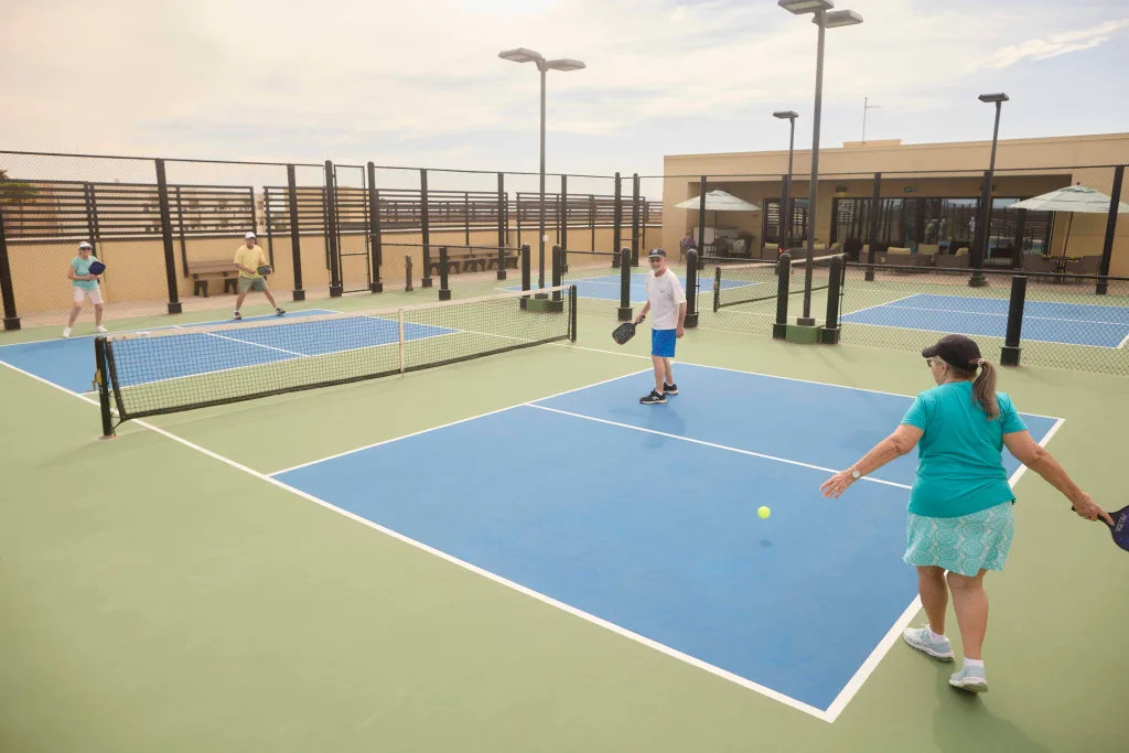 Residents enjoying a game on outdoor tennis courts