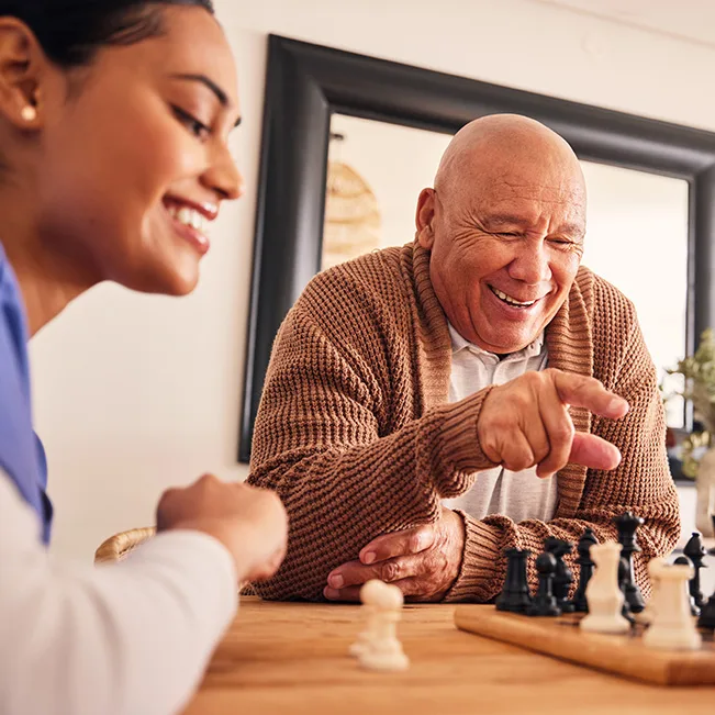 Residents playing chess in a cozy activity room