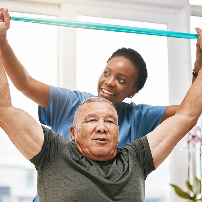 A caregiver assisting a resident with physical therapy exercises